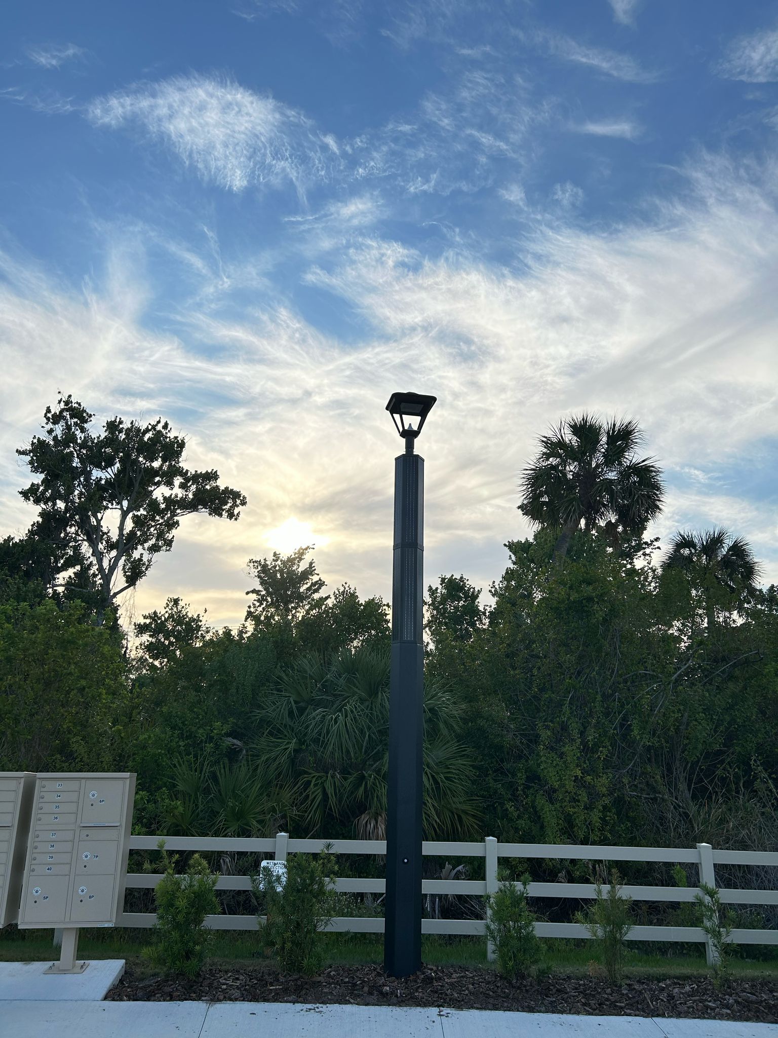 SolarPath solar post-top luminaire by community mailboxes at sunset in Armen Groves