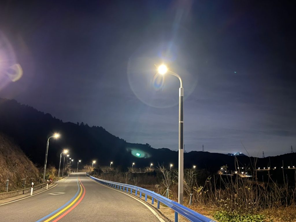 SolarPath solar street lights glowing along a winding mountain road at night